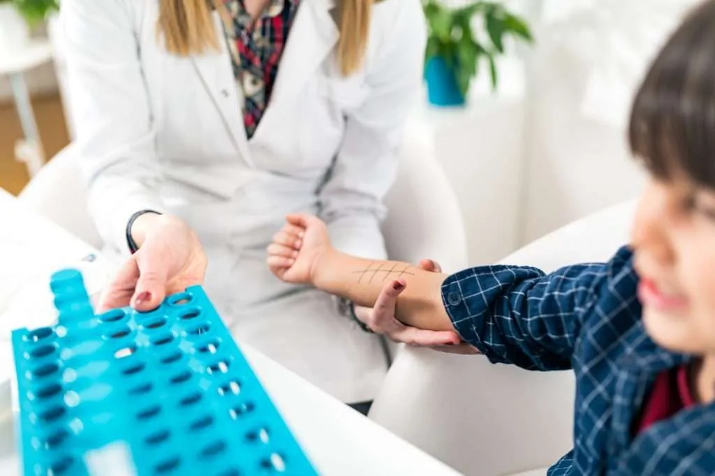 Child getting allergy testing done by doctor at hospital.